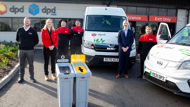 DPD team posing in front of company vans outside a facility