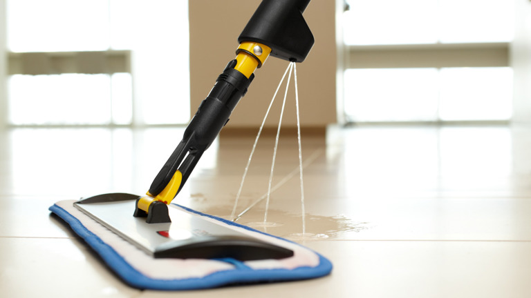 Steam mop cleaning a tiled floor with water vapor visible