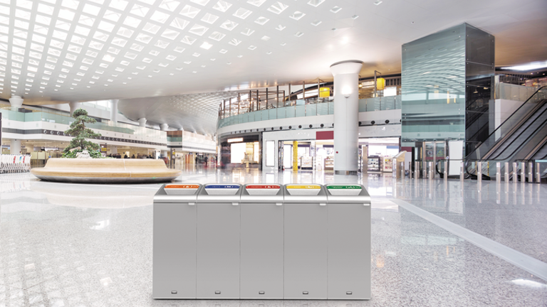 Modern airport lobby with a set of five recycling bins