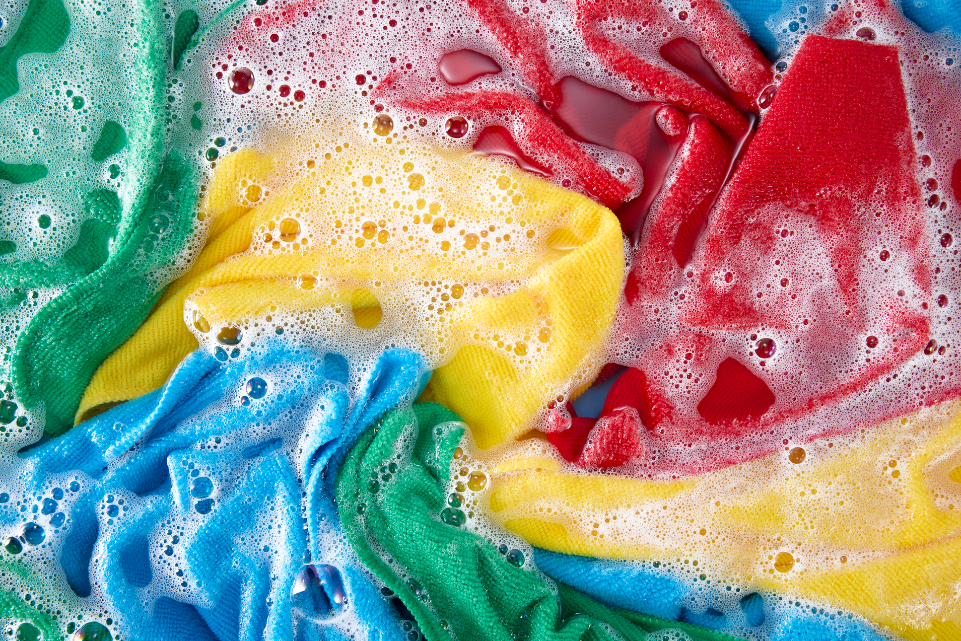 Colorful clothes soaking in soapy water