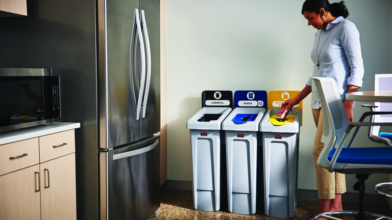 Woman sorting waste into recycling bins labeled landfill