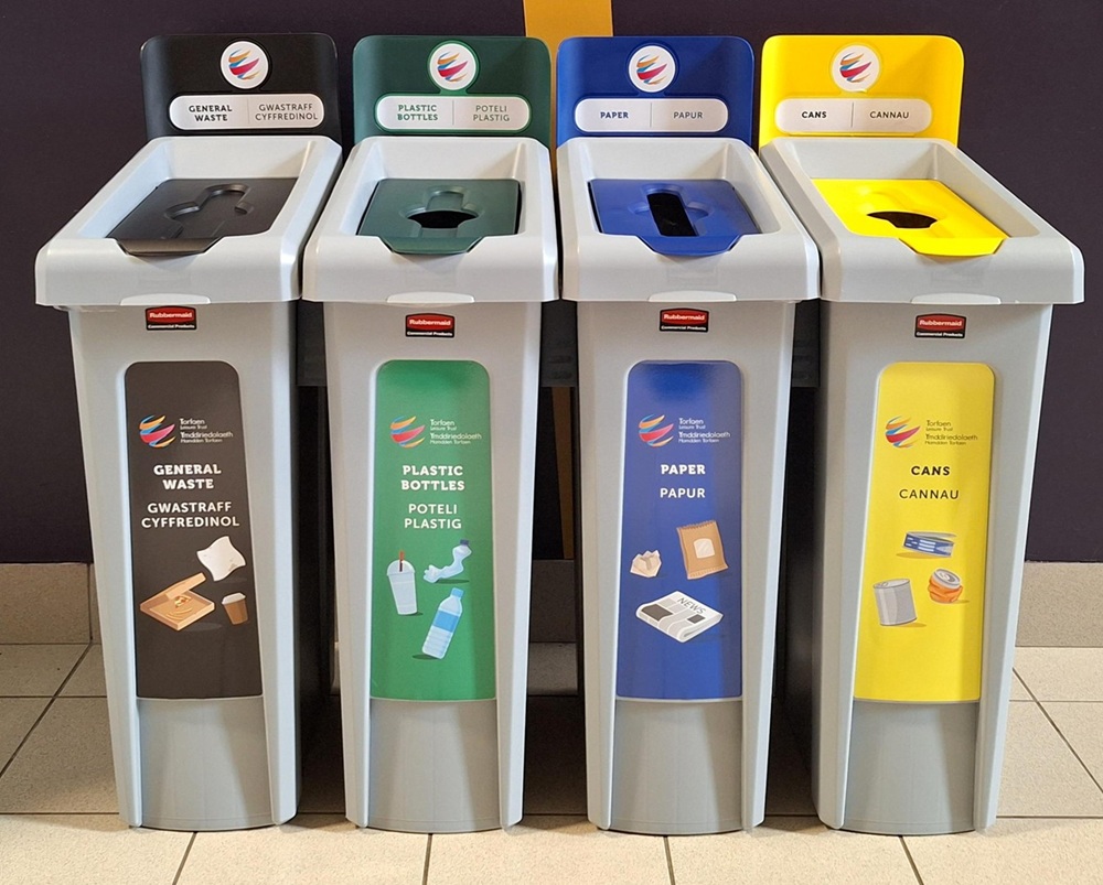 Four labeled recycling bins for general waste